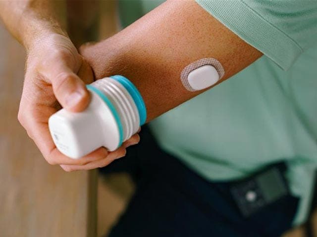 Close up of person inserting Simplera Sync sensor